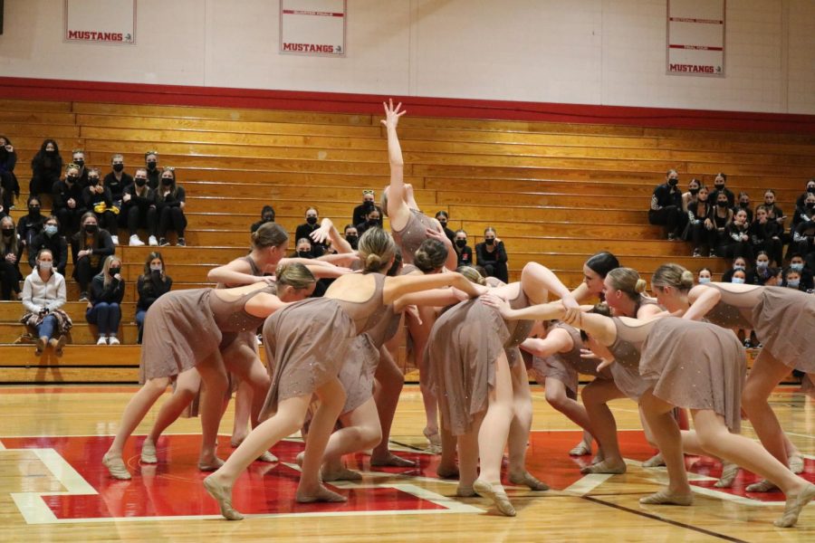 Sophomore Cara Ziemnisky reaches high as the rest of the team gathers around her.