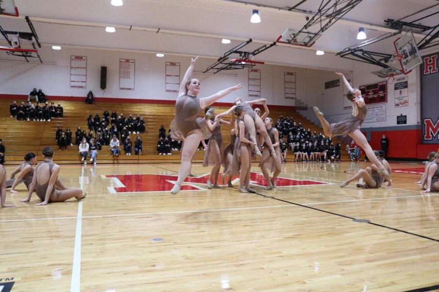 Sophomore Natalie Zelenka is lifted into the air as seniors Sarah Wolter (left) and Molly Wallace (right) complete a firebird jump.