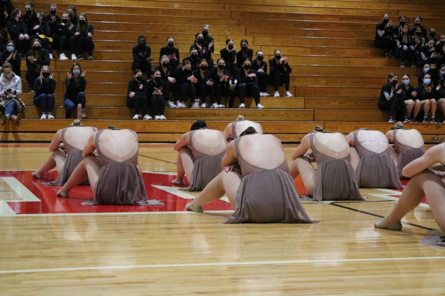 The team concludes their dance with their backs turned to the audience.