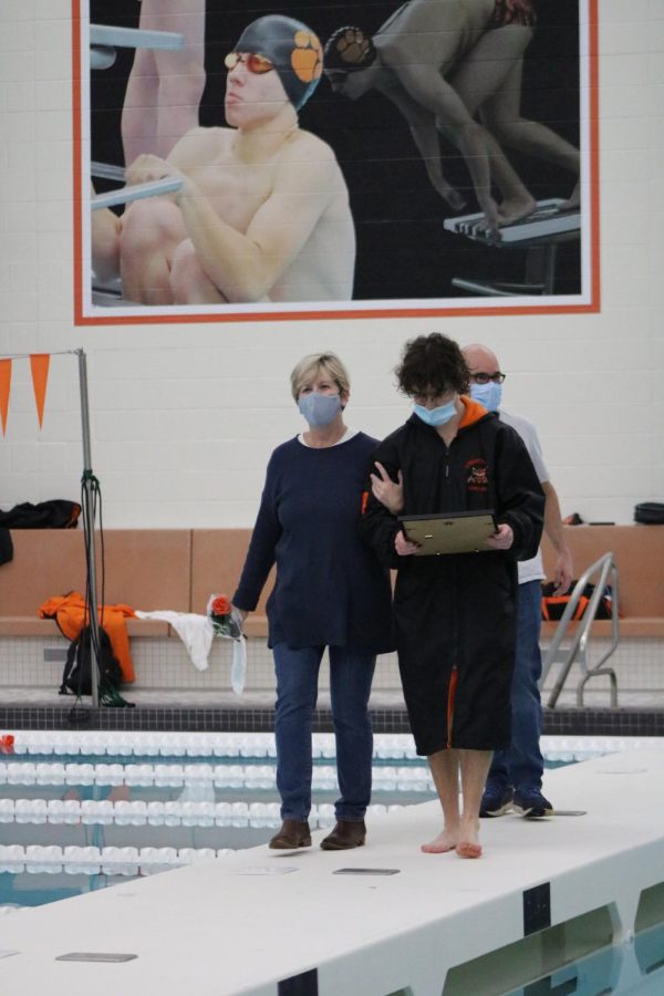 Senior Jack Hamilton is escorted by his parents during senior night festivities. 