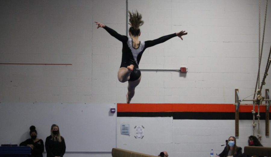 Sophomore Ally Humbert exhibits an incredible leap on the balance beam. 