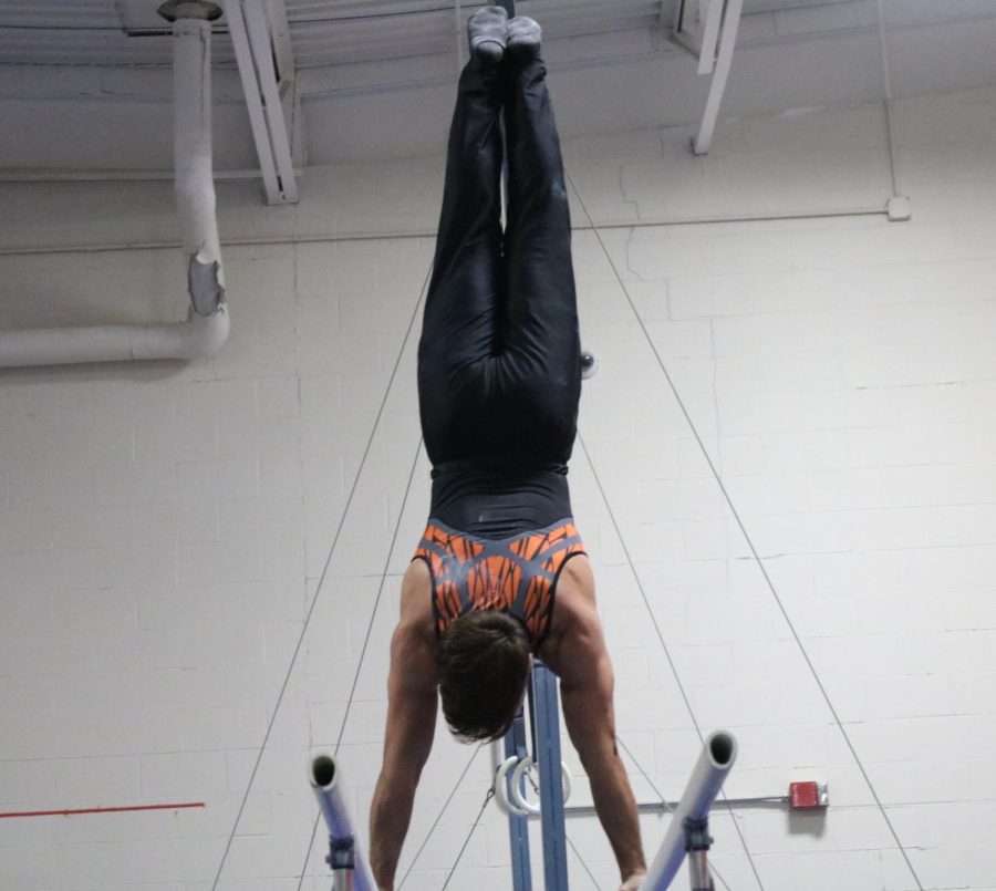 Cabrera does a handstand on the parallel bars. He also competed on floor, pommel horse, still rings, vault, and high bar.