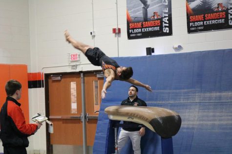 Senior Carlos Cabrera performs a front handspring on the vault, earning him a score of 7.200 points. He placed third as his all around score.