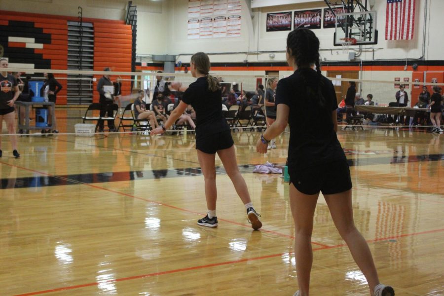 Senior Ella Baffico prepares to serve while her doubles partner, sophomore Kendall Brooks, backs her up after winning a point.