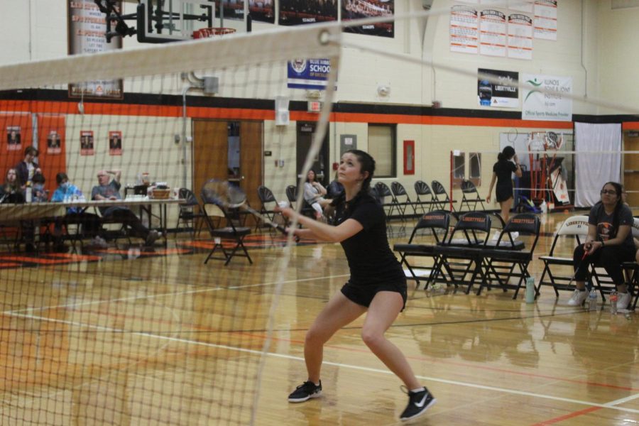 Senior Haley Petz shuffles and hits a drive to gain a point.
