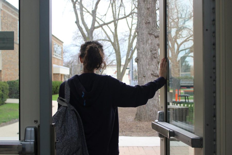 A student exits LHS, representing leaving high school in the past and the search for new beginnings with the start of college.