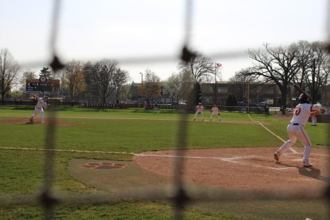 Dylan Holmes prepares to swing as he watches the pitcher deliver the ball.