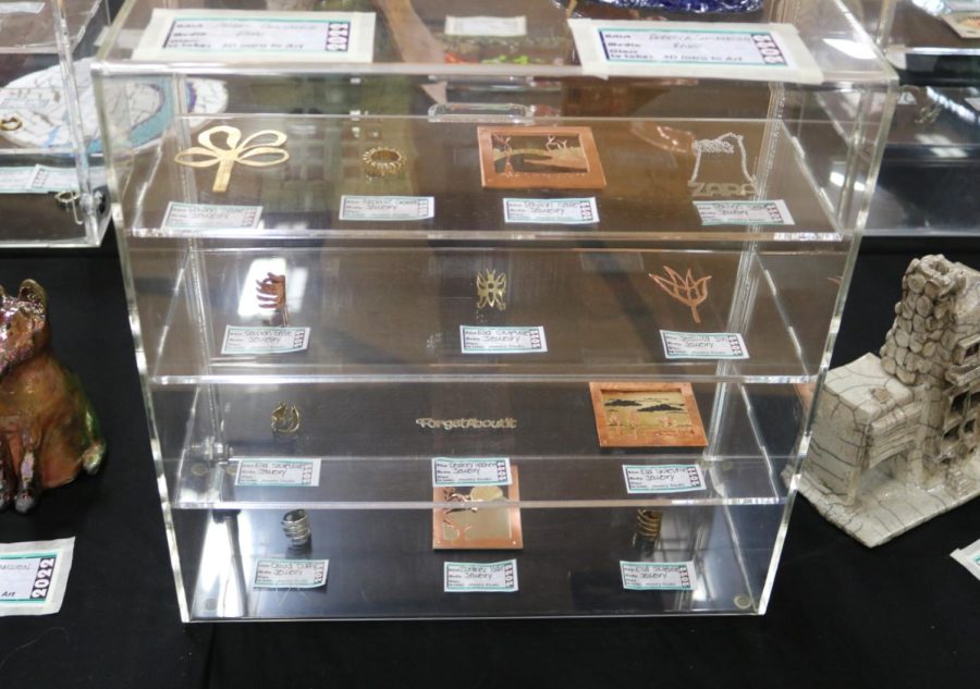 Cases around the gym displayed the work of Jewelry Metalsmithing Studio students. Wax cast rings, made from carved wax cast in metal, and layered metal paintings intricately cut from sheets of metal were just some of the projects displayed in the show.
