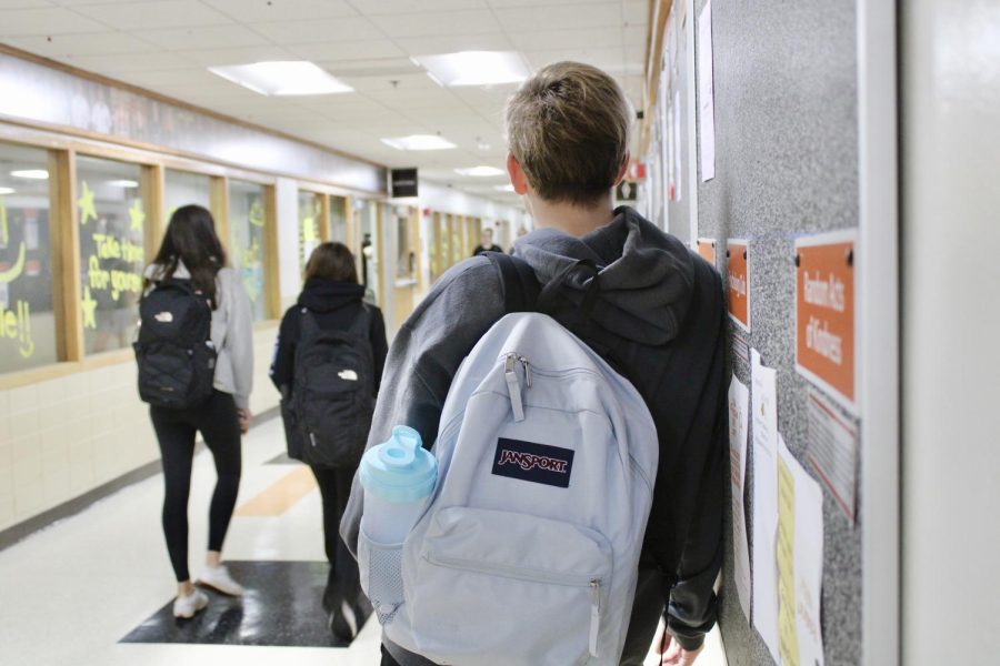 Sophomore Nicholas Ozimek leans against the wall in attempt to distribute the weight of his backpack. In order to prevent long-term side effects such as muscle tension and misalignment in the spine, students should carry no more than 10% of their body weight in their bags.