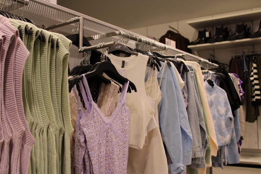 A display at H&M is filled with popular trends at the moment, such as sweater vests, slip dresses, and oversized button downs. Most likely, in a couple weeks the items displayed today will be on the sales rack because of the accelerated trend cycle, which causes pieces to rise and decline in popularity at a faster rate. 