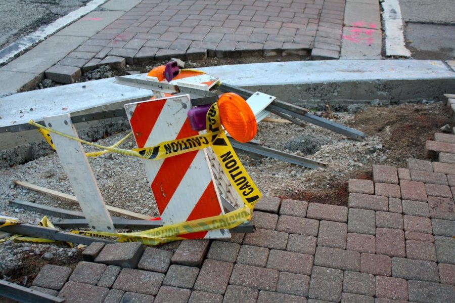 A damaged construction sawhorse warns pedestrians to be careful. Before curbs are replaced, and even during construction, curbs can present hazards for people in wheel chairs or the elderly. 