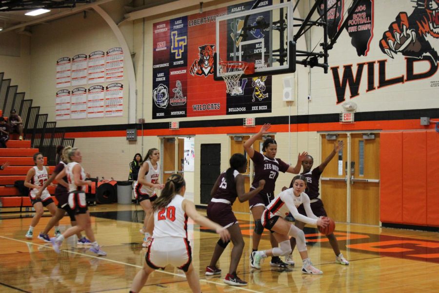 Despite being triple-teamed, senior Emily Fisher (3) passes to senior Lily Castro (20).