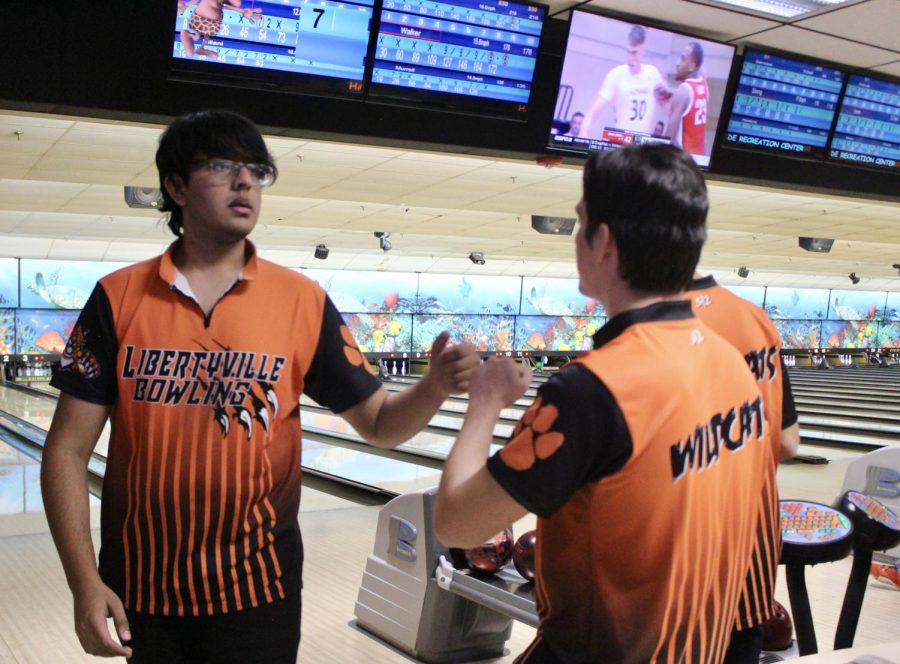 Junior Tarun Movva fistbumps teammate after hitting a spare.