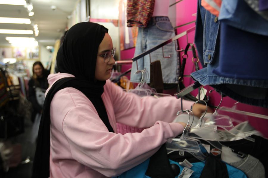 Junior Ranya Belabbes sifts through clothes at Plato’s Closet. The thrift store offers many options for clothes, sorted by age, size, preference, style and more.
