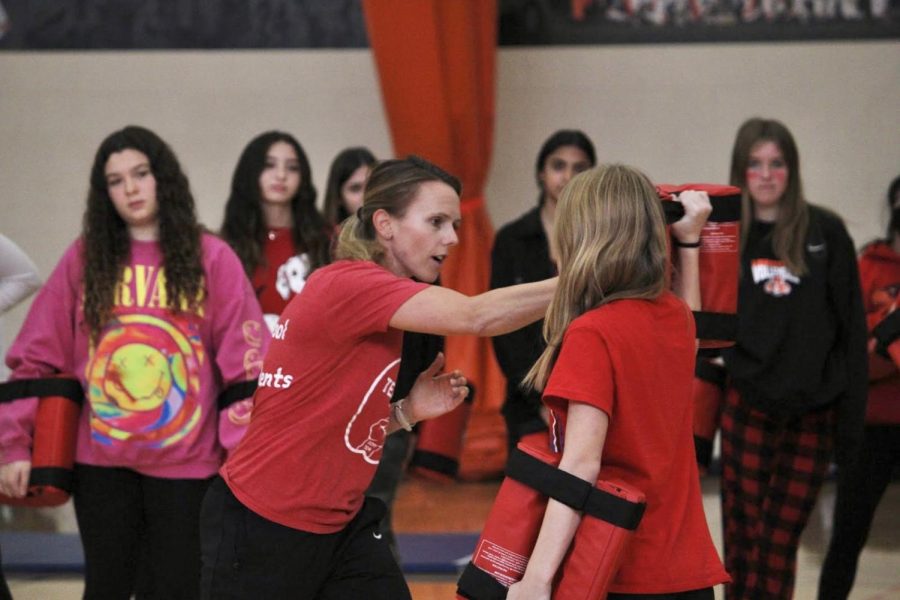 Ms. Bethany Martin, who teaches freshman PE and drivers education, took a RAD class on her own and earned certification seven years ago at Oak Park River Forest High School. Here she demonstrates to students how to block an attack against them. 