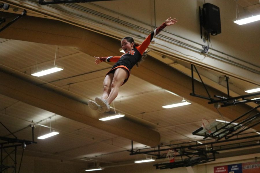 Freshman Kaileigh Sullivan flies through the air at halftime, representing the LHS varsity cheer team who kept the energy going throughout the game. 