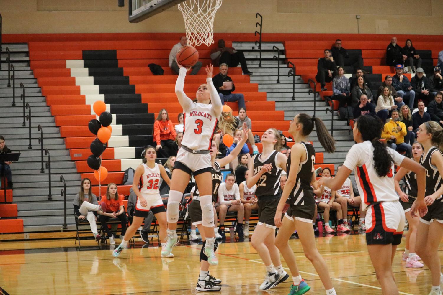 Senior Emily Fisher (3) starts off the fourth quarter with a layup, carrying the Wildcats to a lead of 41-39.