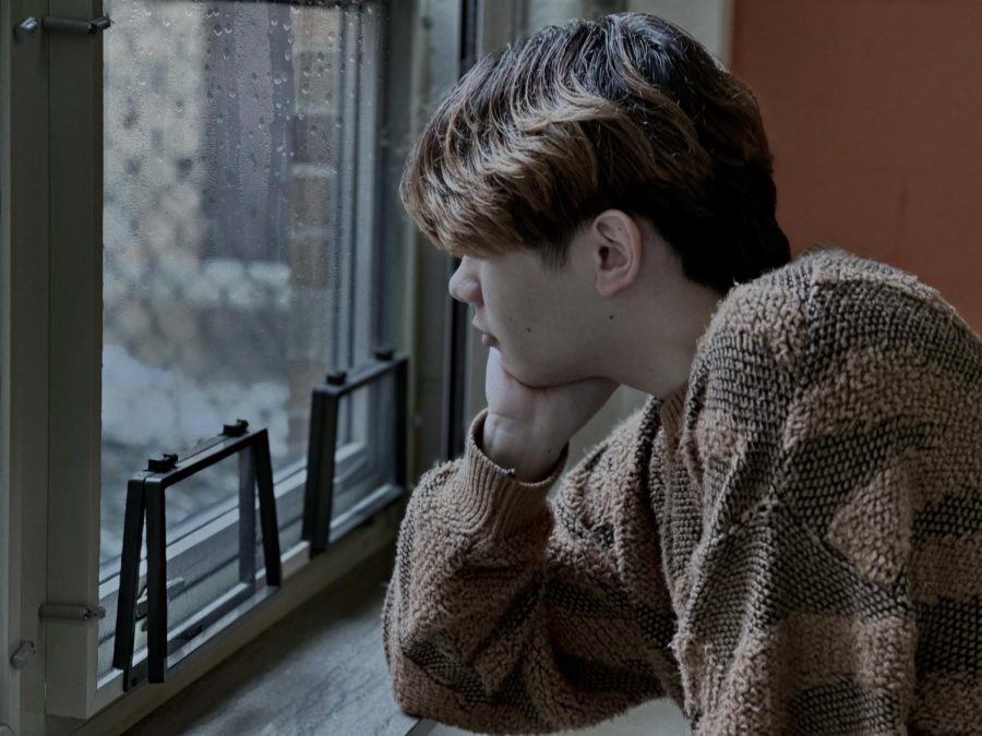 Senior Nico Adriano peers out the window at the gloomy scenery outside. When taking another glance, however, the sun is shining through enlightening Nico and allowing for a positive outlook on the day ahead. 
