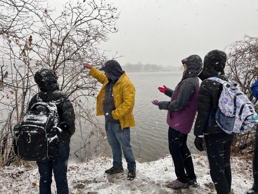 ECOS+co-presidents+Finley+Roman+and+Atalhea+Herman+learn+about+invasive+plants+surrounding+Butler+Lake+from+an+environmental+conservationist.+The+Butler+Lake+restoration+began+on+Jan.+21+in+hopes+to+solve+the+erosion+problem.