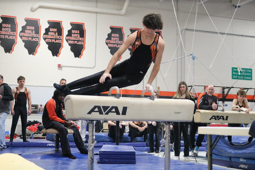 Senior Chris Benavides swiftly maneuvers around the pommel horse, earning 6.20 for the varsity team.