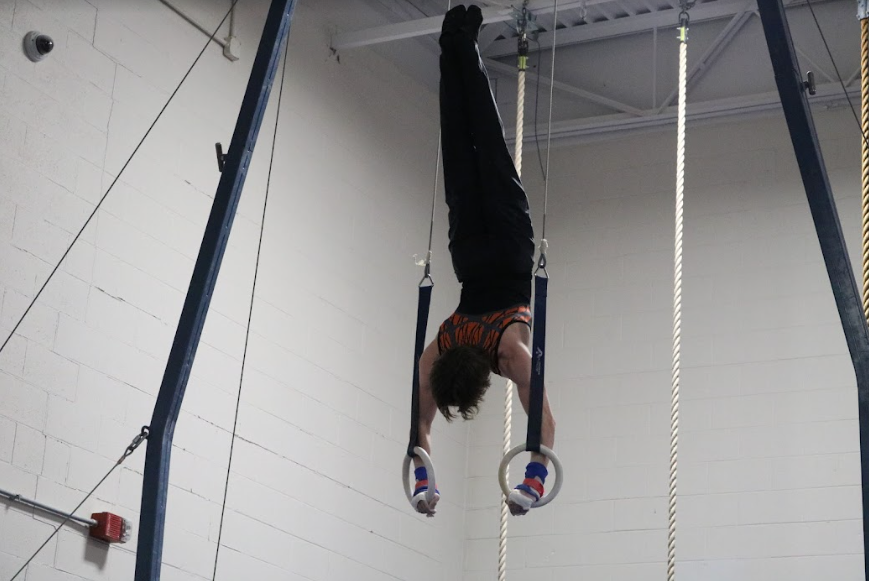 Senior Josh King maintains his form, before swinging back down into his next move. King earned a 7.10 on the still rings for the varsity team, which, like Jenkinson, he has been a part of for three years.
