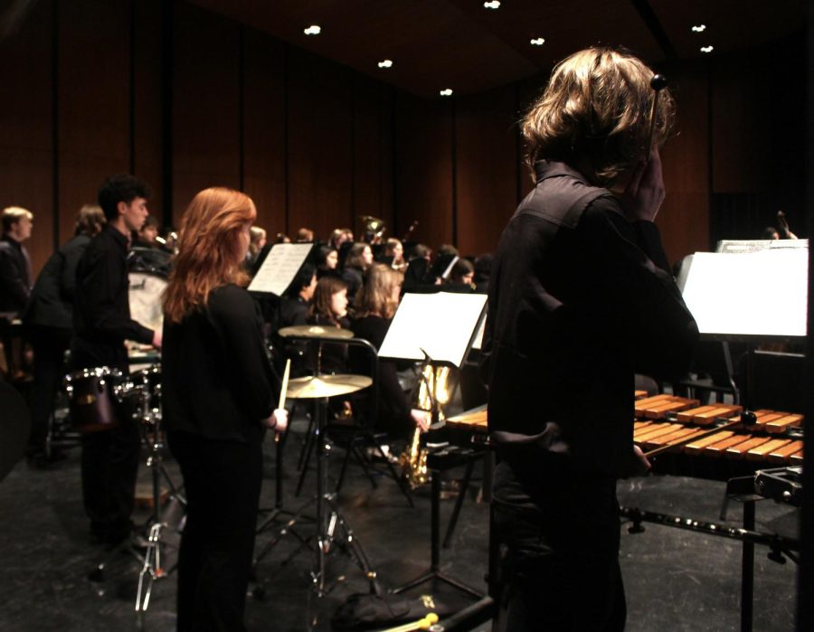 Junior Mathew Reichrad and sophomores River Thompson and Nina Landvick, who are also members of the marching band drumline, stand by waiting for their cue to join the orchestra in performing “American in Paris” by George Gershwin.