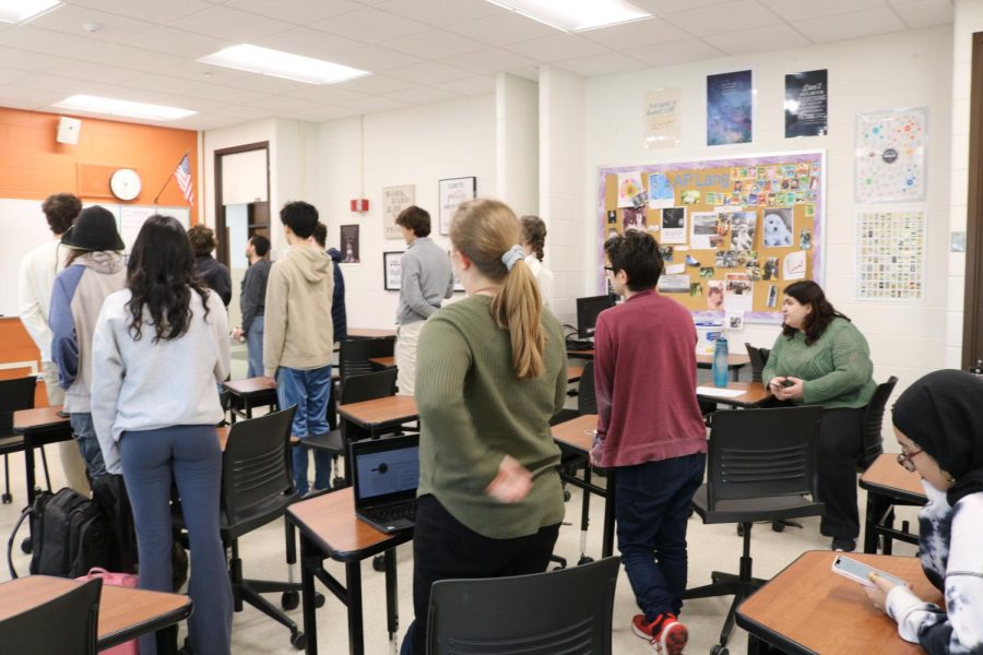  Mr. Gluskin’s AP Seminar class’s environment while the pledge is announced over the intercom.5 girls respectfully choose to stay seated while the rest of the class stands.