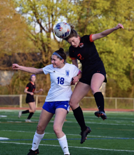 While locked in a battle with Lake Zurich senior Sam Keating (18), Libertyville senior Mabelle Kosowski (16) intercepts the ball to secure possession for the home team. (Photo courtesy of Mr. Kevin Griffin)