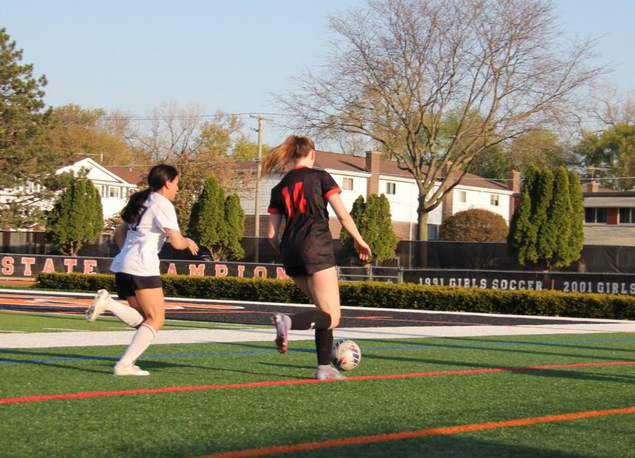 Senior and defender Megan Roberts (14) protects the ball from a Zion-Benton player. Key defense was necessary in order to achieve the team’s shut-out win against the Zee-Bees, with a final score of 8-0.