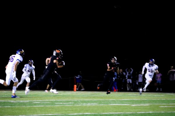 Junior Josh Holst (9) runs the ball down the field with Lake Forest juniors Jack Walsh (42) and Aedan Cassidy (46) hot on his heels. Holst, also a baseball player, had a phenomenal run for the Wildcats in the first quarter.