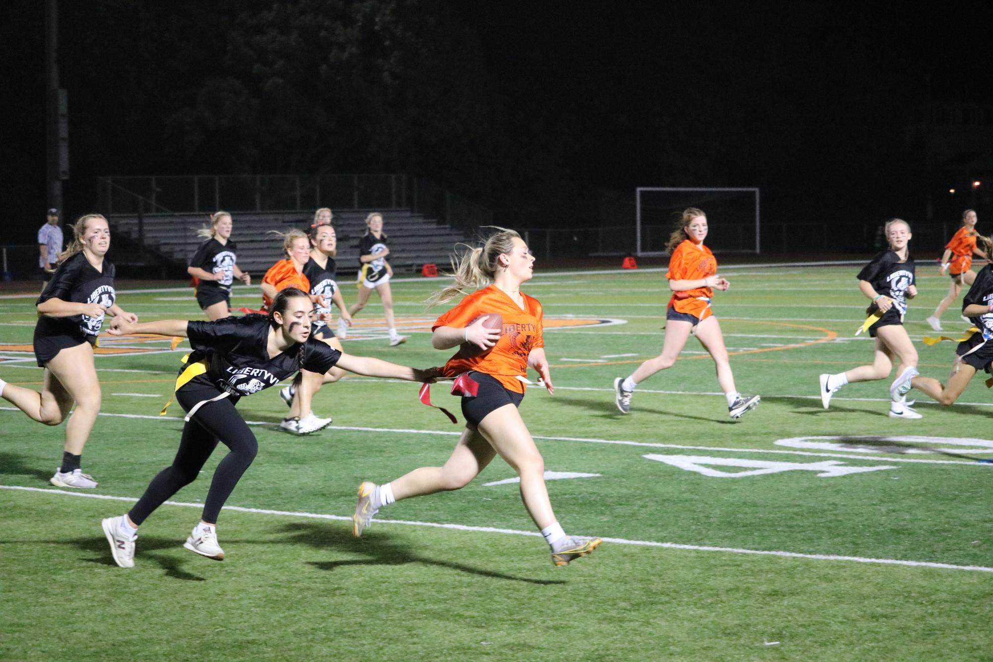 Senior Cate Gordon, who was the only orange team player to score a touchdown, gets her flag pulled by senior Heather Gangi during the last quarter. 