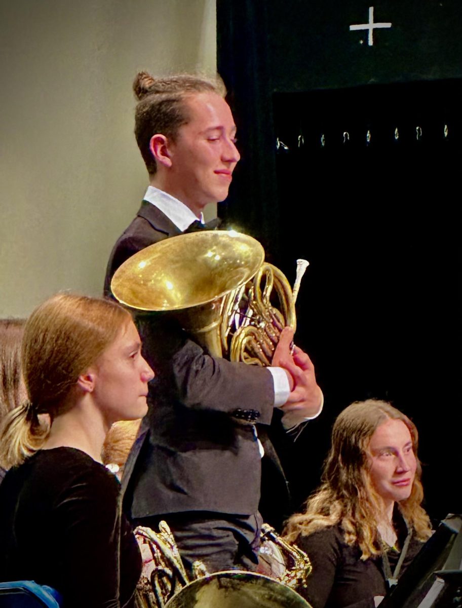 Julian Kolthammer, who played a solo on the french horn, stands for acknowledgement after the song ends.