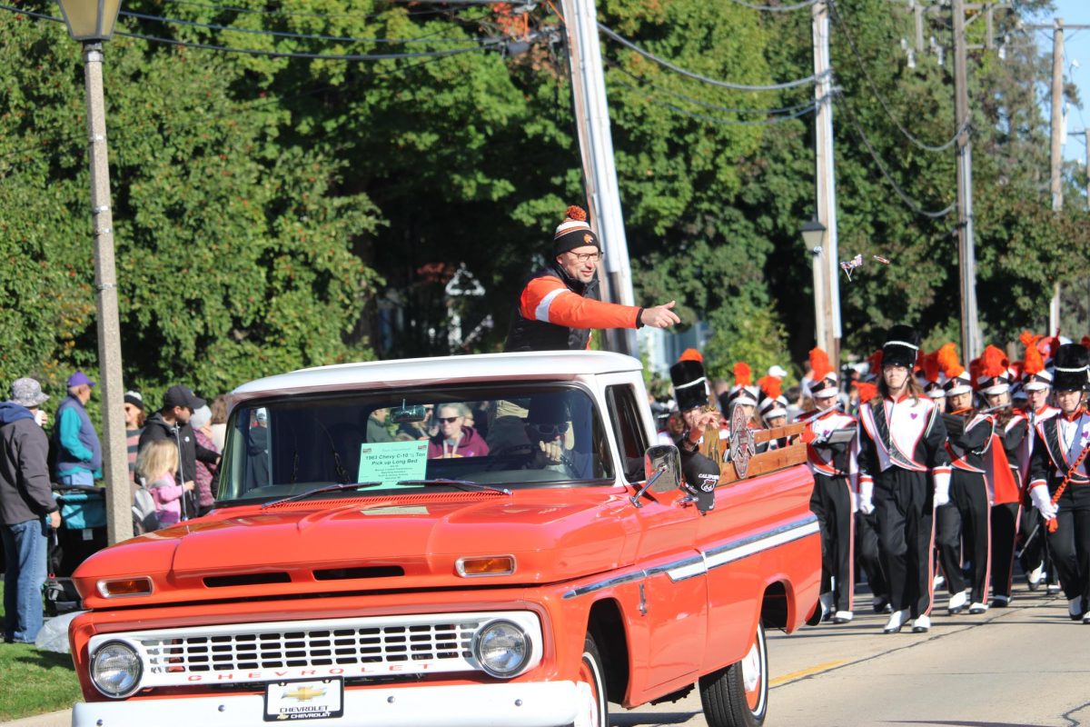 The annual parade begins with Libertyville High School principal, Dr. Koulentes (Dr. K), riding in the back of an old pickup truck, throwing candy to kids anxiously awaiting the sweet treats.