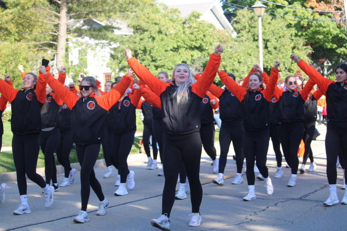Staying on point, the cheer team performs a simple routine as they walk to keep the crowd entertained and energy high.