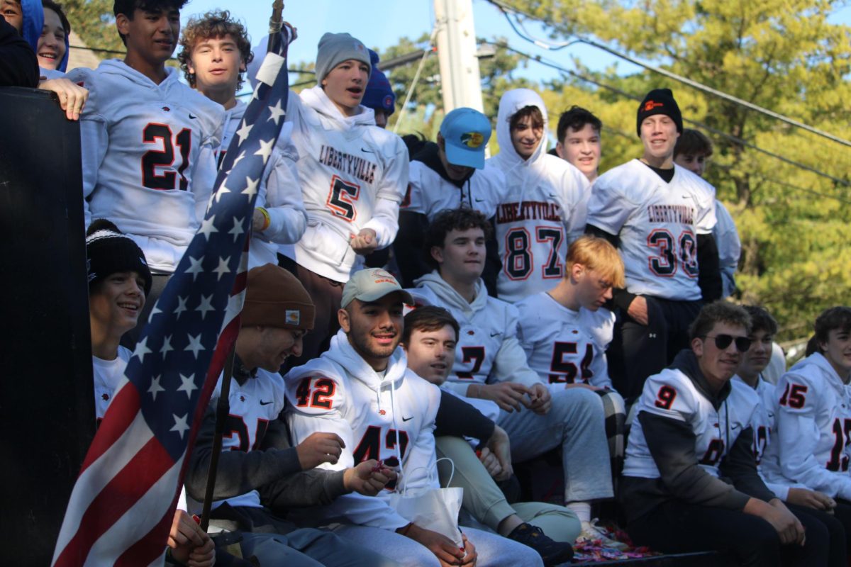 Coming off a win from the previous night, the varsity football team rides down the parade route to share their spirit. The team beat the Mundelein Mustangs 41-0 to secure their fourth win of the season, especially impactful after a previous-year homecoming loss to Lake Zurich.