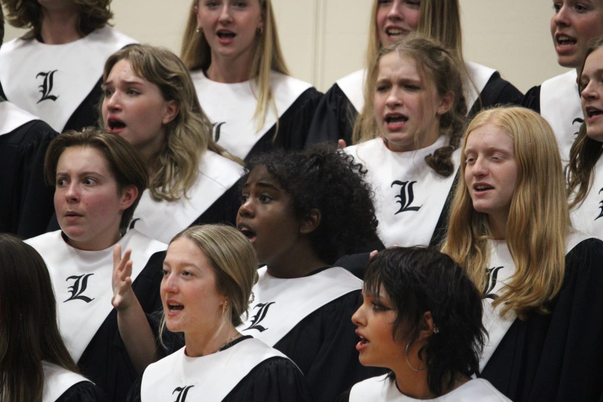Choir Board president and senior Grace Schulenburg (second from top, furthest left), along with other concert choir seniors, sings the “Nightmare Before Christmas Medley,” contributing to the concert’s spooky atmosphere. 