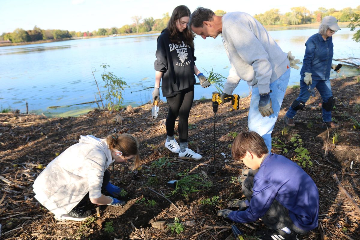 Senior Atalhea Herman (Left), freshman Meredith Fein and freshman Jake Simpson work with Mr. Dave Lapish, advisor of LEAF, on planting by the shoreline to prevent further erosion. 