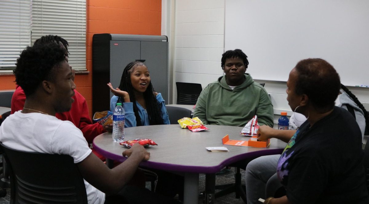 Senior Damarion Baker (left), junior Javonta Booker, junior Chalri Rainey, senior Iyana Gullet, junior TJ Frazier and Black Student Union advisor Ms. Sharra Powell participate in a karaoke card game. 
