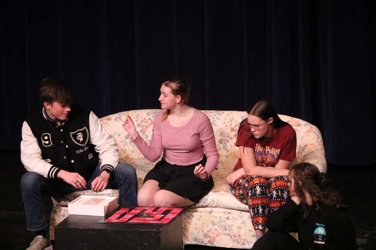 Under the face of boredom, Chloe, played by junior Delaney Rybicki, shows off her new board game to her friends. Although in the beginning the ridiculous tasks, such as licking the floor, may seem harmless, they later turn deadly as each character fights for their lives after the introduction of Barnabas Grim, played by junior River Thompson.