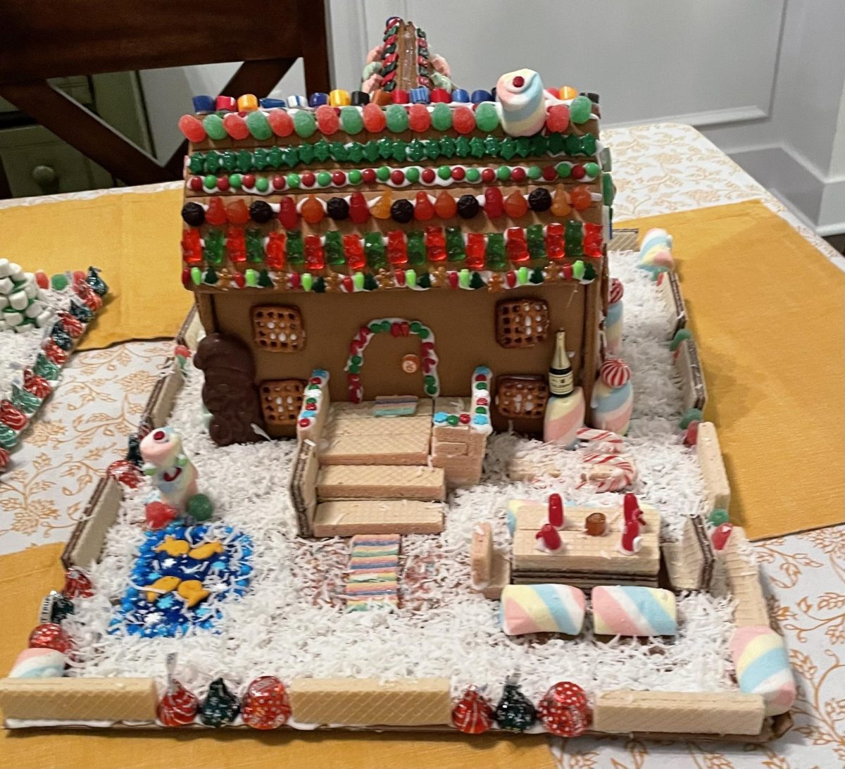In 2021, I created a mansion gingerbread house that I decorated with wafers, pretzels, M&Ms, skittles and marshmallows. One of the spaces of the house that I enjoy decorating is the yard. For example, I added a pond to the yard which was made from wafers and marshmallows and a wafer fence to the backyard of my house. 