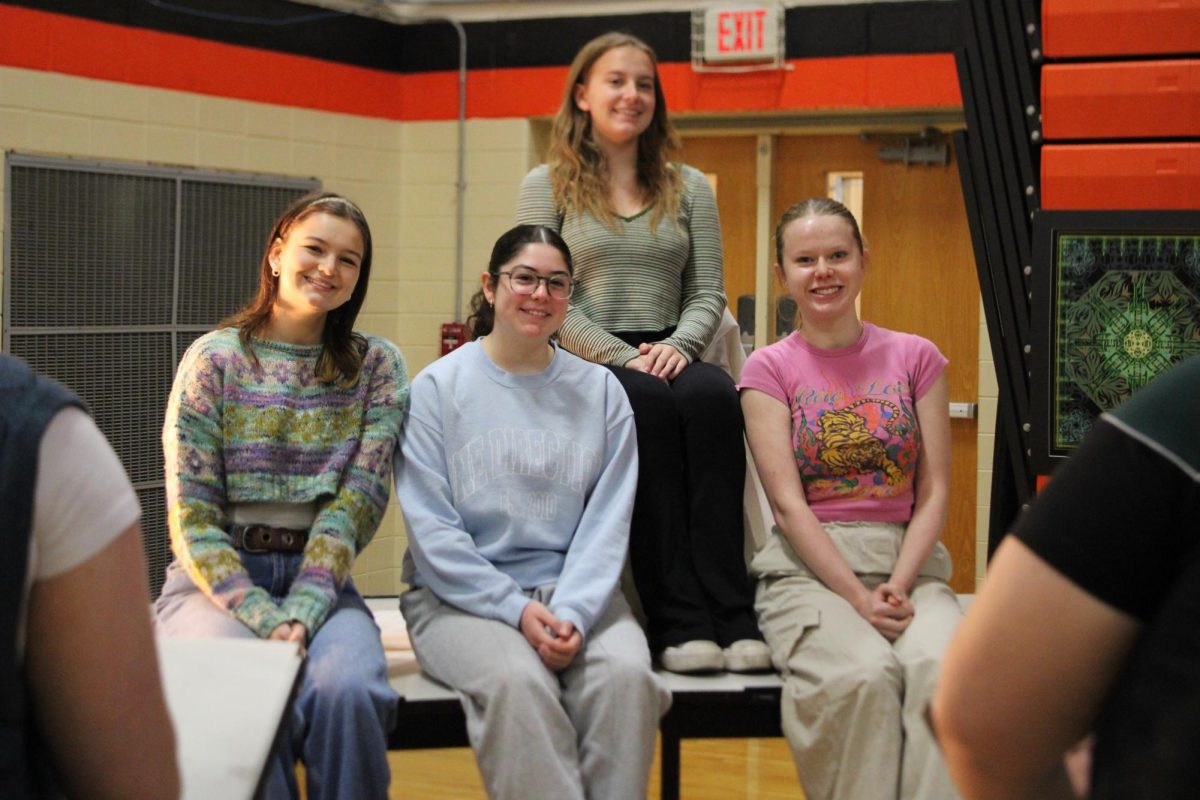 Senior Lorelai Fisher (top), junior Tiffany Fetter (left), senior Megan Lacrosse, and senior Rosemary Scarpelli pose at a free-hand station where multiple AP Portfolio students use them as models to showcase their figure-drawing skills.