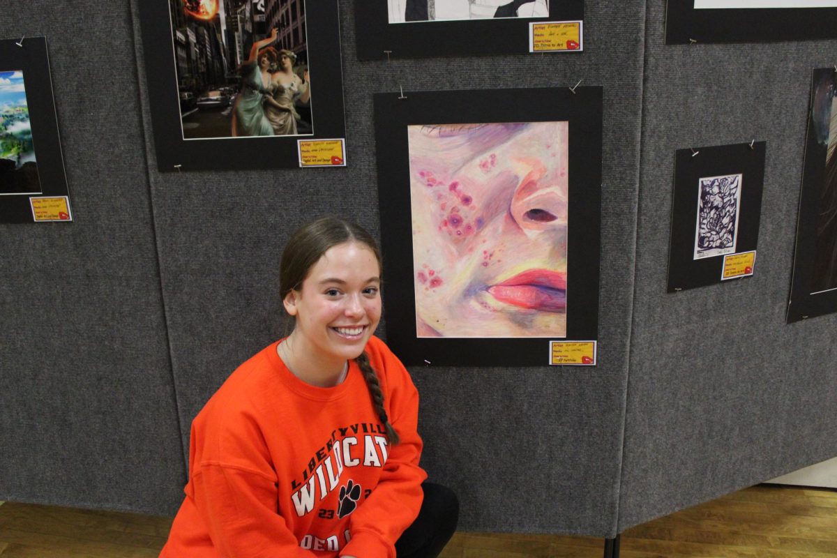 Senior Alaina Weiss poses with her drawing, one of her creations for AP Portfolio. 