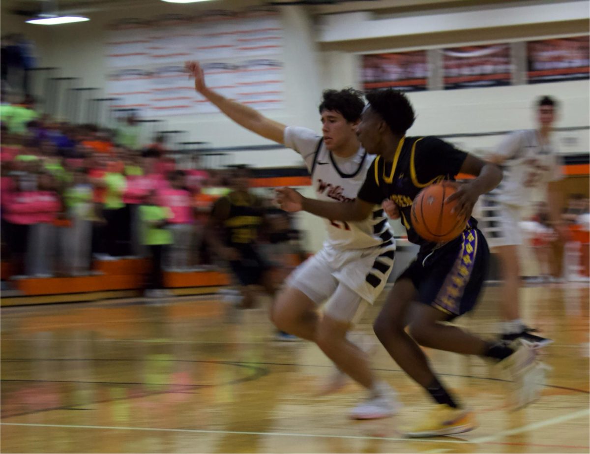 Junior and guard Danny Moreira (21) attempts to cut off his opponent’s drive to the basket.
