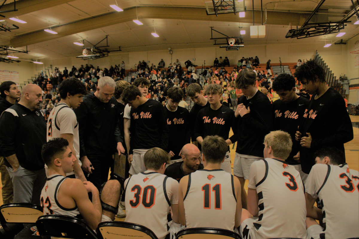 On Jan. 19, 2024, the varsity boys basketball team huddles together during a tough game against the Warren Township Blue Devils. This close game, which the Blue Devils narrowly won 77-69, was a result of the hard work and communication between this team. Senior Henry Calsin said that “whether [we’re] up or down in the game, weve gotten a lot better at knowing how to [communicate] in a good and competitive manner.” 