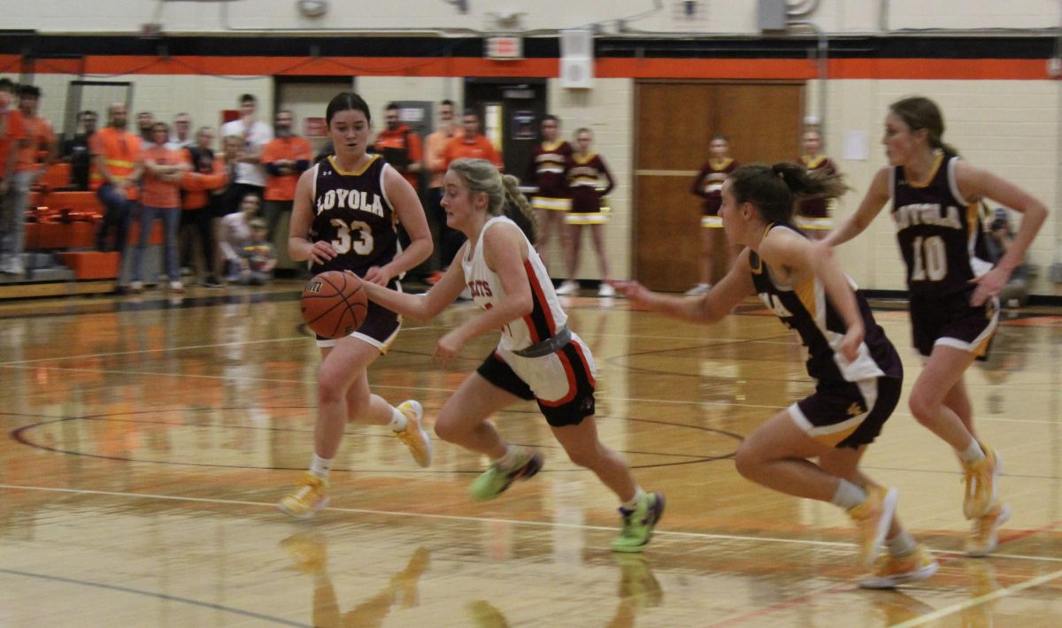 Senior Kate Rule (24) takes the ball down the court, trailed by Loyola senior Paige Engels (33) and sophomore Clare Weasler (10). Despite playing the final game of her high school career, Rule still hopes to see the team continue to display “great team spirit and energy. I think that’s something that’s so vital and so important to this program.”