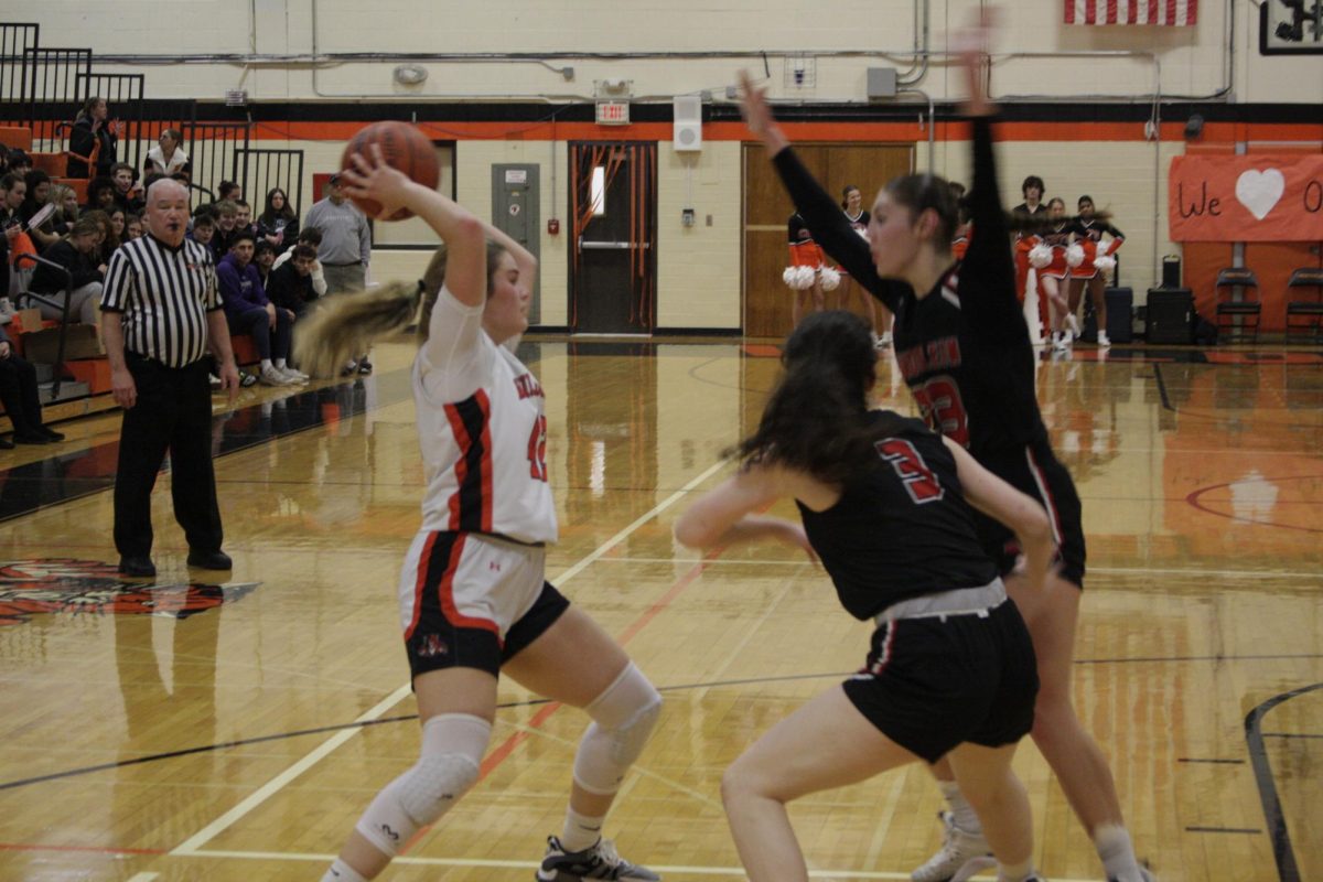 Senior Maddy Kopala (42) looks for an open teammate to pass to as two Mundelein players guard her. Kopala has also recently committed to play soccer at the collegiate level.