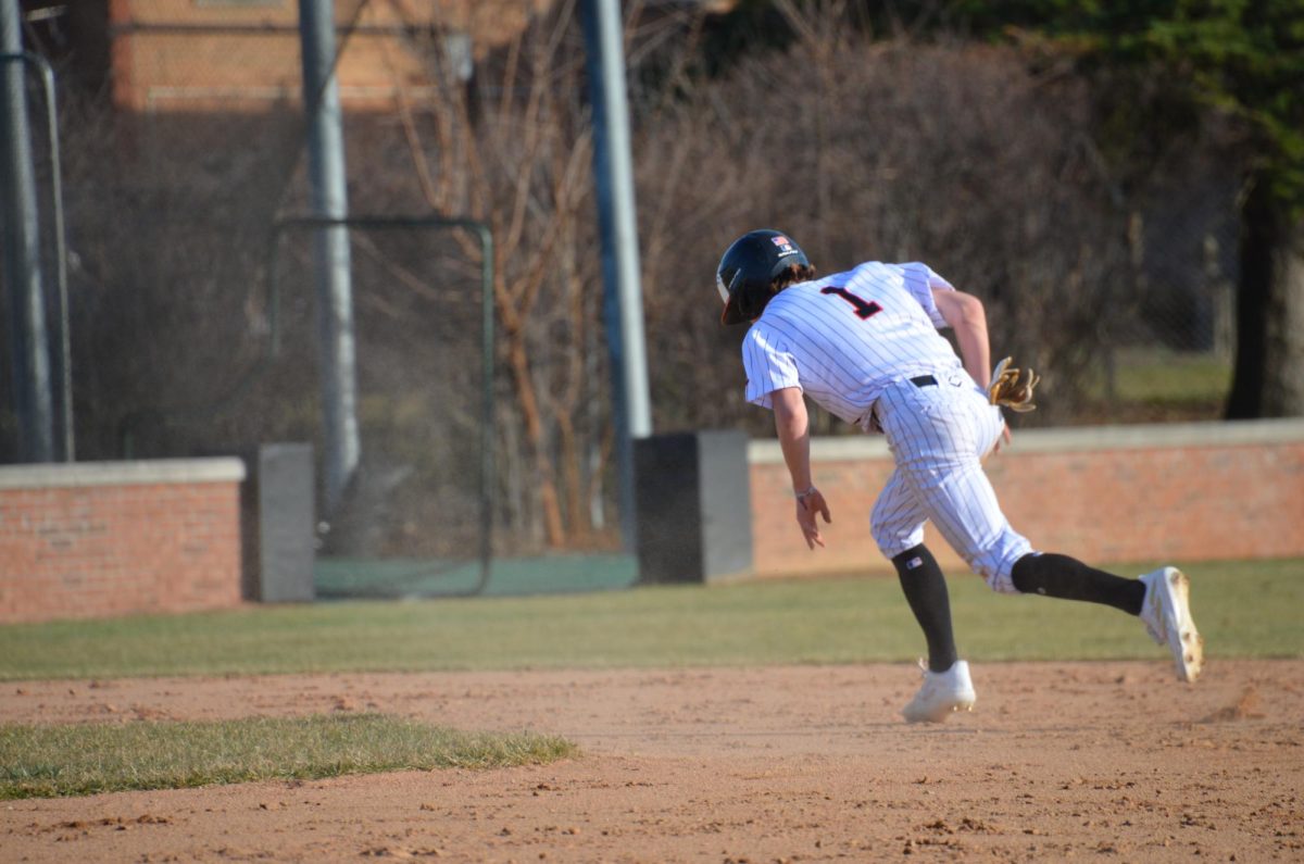 Junior Cole Lockwood (1) rounds the corner to third base after stealing two bases at the bottom of the first inning. 