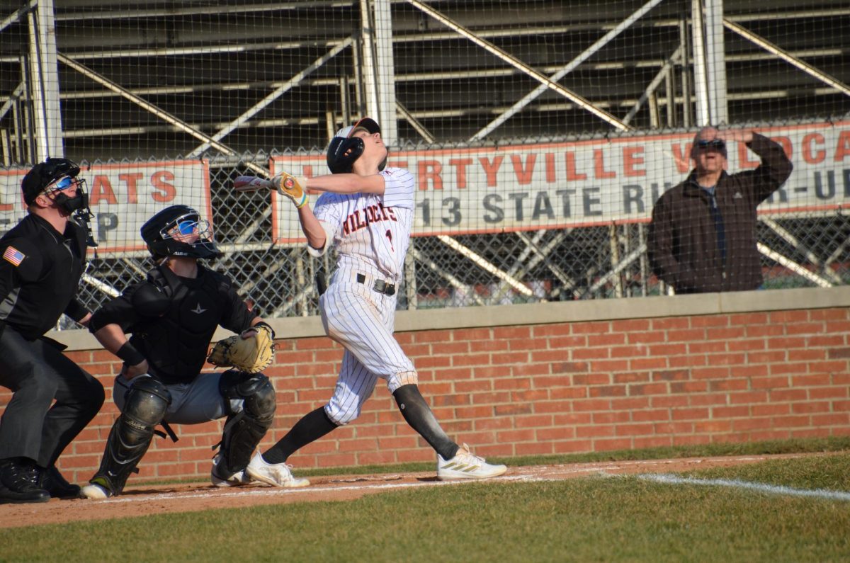 Junior Cole Lockwood (1) watches his ball soar into the outfield, advancing two bases for the Wildcats.