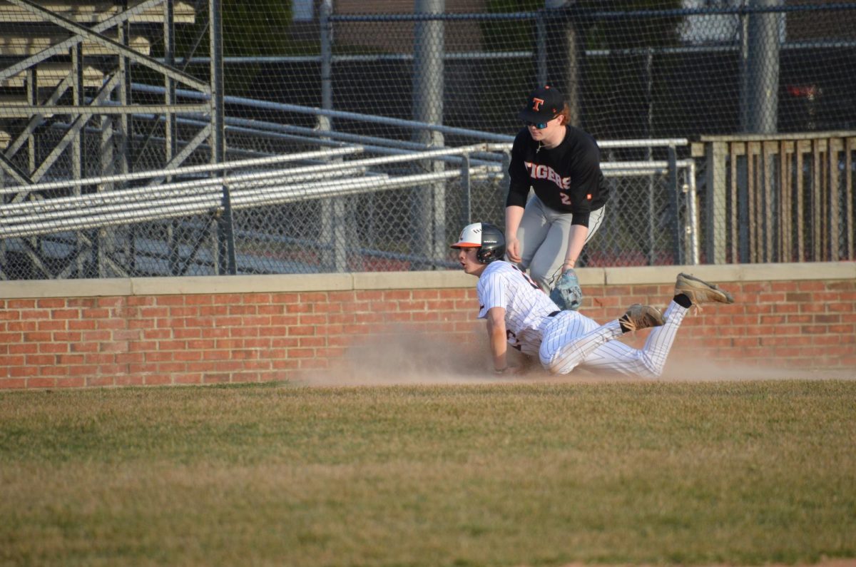 Junior Mason Strader(13) slides into third base at the bottom of the first inning. The first inning saw the start of the home team’s scoring run and they ended the inning up 2-0.