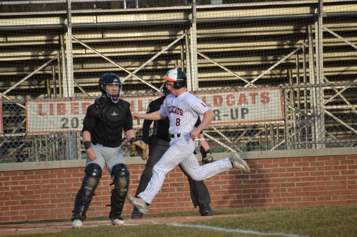 Junior Steve Strelow (8) flies past home plate, scoring another run for the Wildcats, one of 12 that they secured over the visiting Tigers.